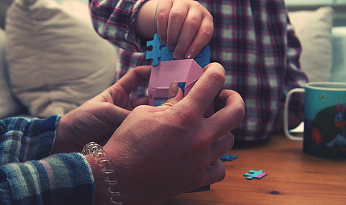 person holding house miniature with puzzle thumbnail