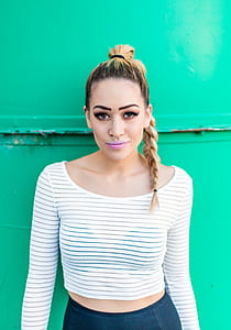 woman wearing crop top leaning on green wall thumbnail