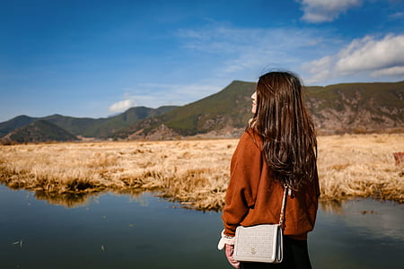 woman standing beside body of water during daytime thumbnail