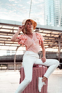 woman sitting on luggage bag at daytime thumbnail