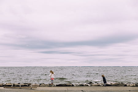 two girls standing near body of water thumbnail
