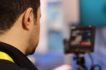 man wearing black collared shirt near flat screen monitor thumbnail