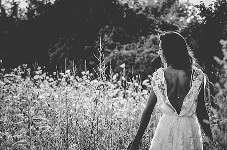 grayscale photography of woman in dress near plants thumbnail
