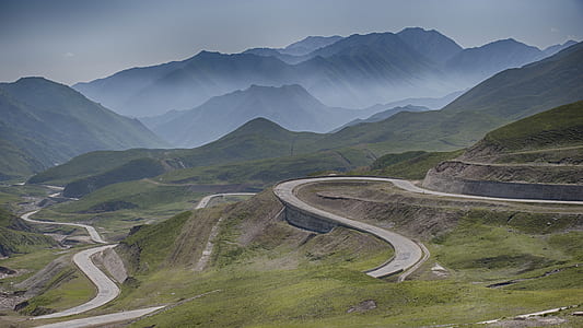 landscape photo of brown concrete road near mountains thumbnail
