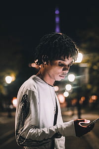 man standing on park while using phone at night thumbnail