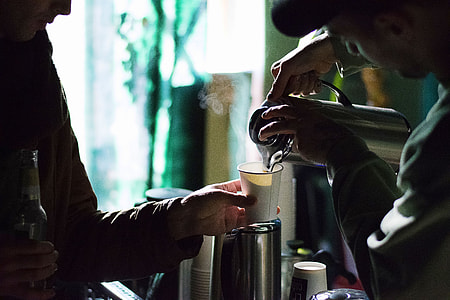 man pouring hot water in white coffee cup on man's hand thumbnail