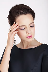 woman wearing black boat neckline top holding her head thumbnail