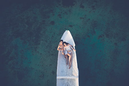 man and woman sitting on white boat thumbnail