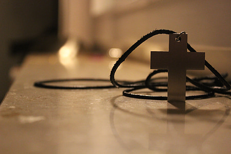 selective focus photography of silver-colored cross pendant thumbnail