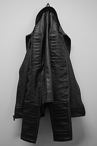black leather jacket hanging on white wall thumbnail