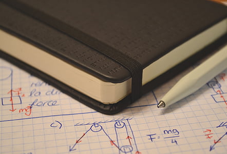 white pen beside black notebook thumbnail