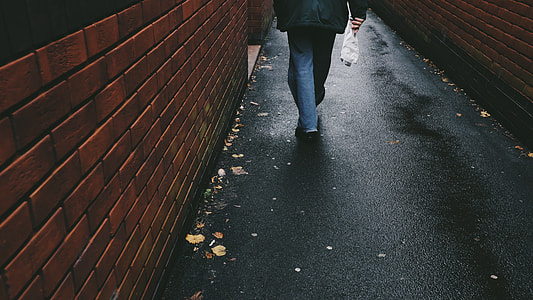 person walking on black concrete road thumbnail