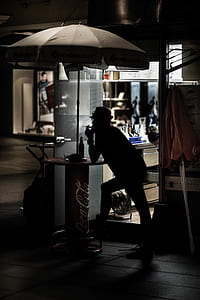 silhouette of man standing near stand table thumbnail