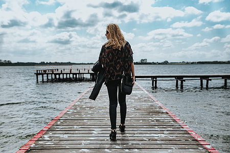 Beautiful blonde woman on a wooden pier by the lake thumbnail