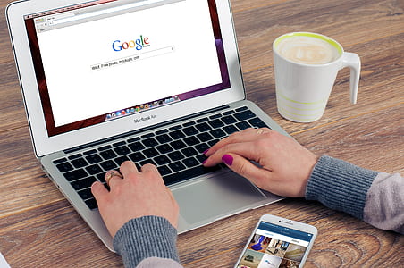 person in front of MacBook Air with mug of coffee on table thumbnail