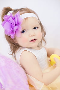 toddler girl wearing white sleeveless dress with purple and white headband looking side thumbnail