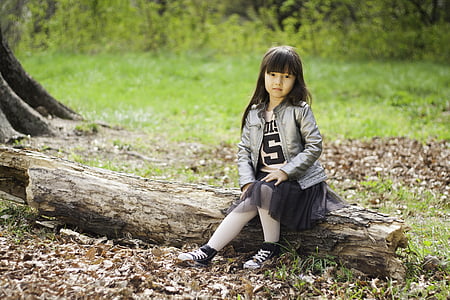 girl sitting on tree tuck on grass field thumbnail