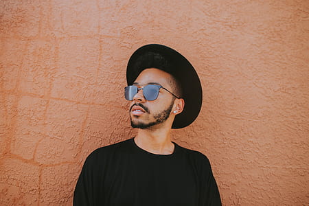 man in black crew-neck shirt wearing black aviator sunglasses and hat thumbnail