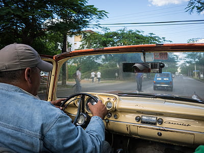 man driving brown Chevrolet vehicle on road thumbnail