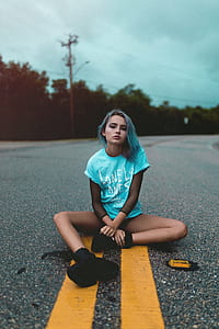 woman sitting on gray pavement road thumbnail