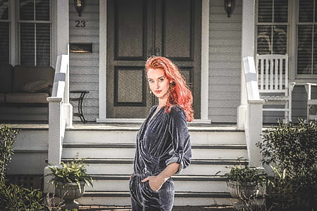Woman in Gray Jumpsuit Standing in Front of House thumbnail