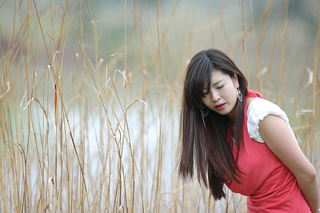 woman in red and white dress beside haystack field thumbnail