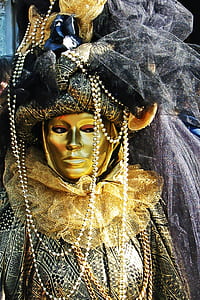 person wearing gold-colored mask thumbnail