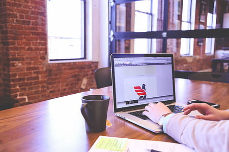 man operating laptop computer on top of table thumbnail