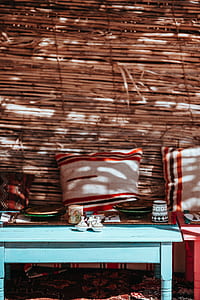 photography of plates and cup on coffee table beside sofa with throw pillows thumbnail