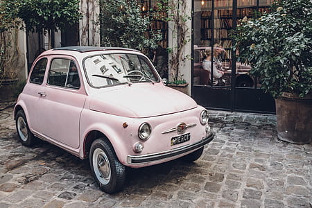 vintage pink car parked beside the window thumbnail
