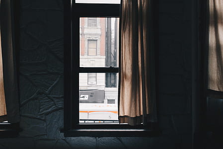 clear glass window showing brown house during daytime thumbnail