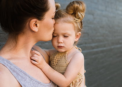 woman carrying girl kissing on forehead thumbnail