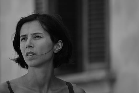 greyscale photo of woman neqar window thumbnail