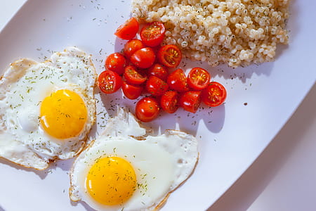 two sunny side-up eggs with sliced cherry tomatoes thumbnail