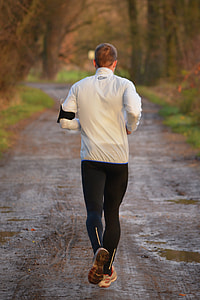 photo of man in white and black shirt and sweatpants jogging on field thumbnail