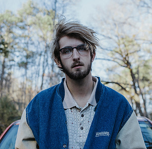 man in blue jacket standing behind red car during daytime thumbnail