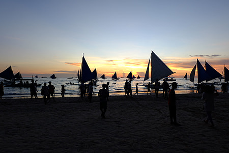 silhouette photography of people standing on sand near seashore thumbnail