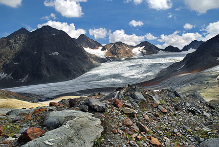 gray and brown stones beside mountains at daytime thumbnail