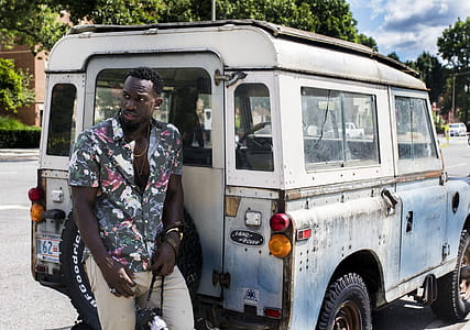 Man Stands Near White Land Rover Defender at Daytime thumbnail
