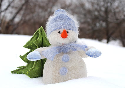 snowman on snow during daytime thumbnail