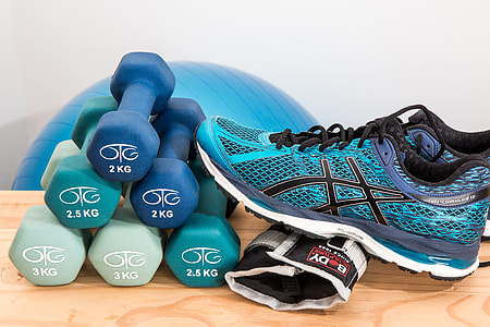 six 2 kg fixed weight dumbbells and Asics running shoe on brown table thumbnail