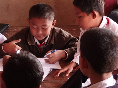 boys gathered around wooden table thumbnail