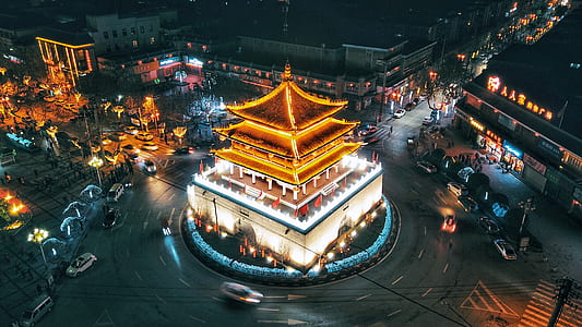 brown pagoda in between intersection during night time photography thumbnail