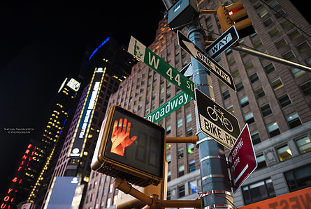 assorted street signages beside brown concrete building thumbnail