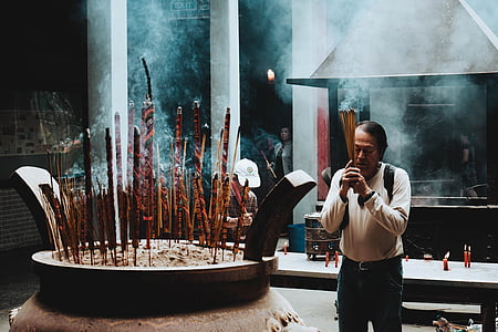 man standing in front of incense thumbnail