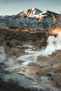 aerial photo of smoking river near white and brown mountain thumbnail