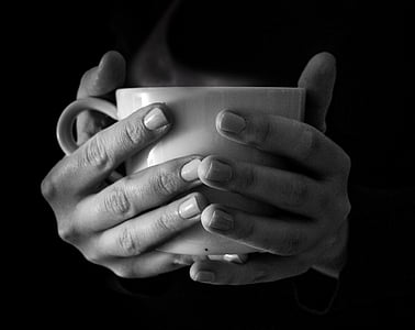 grayscale photo of person holding ceramic mug thumbnail