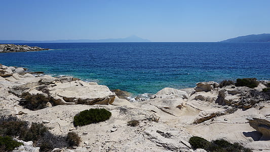 gray sand in front blue ocean water thumbnail