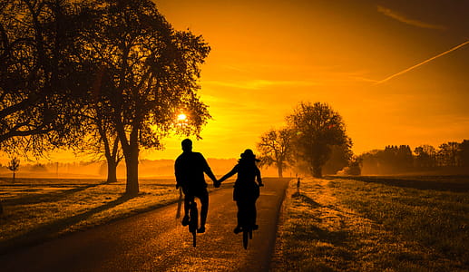 Photo illustration of couple on a bicycle in evening country landscape thumbnail