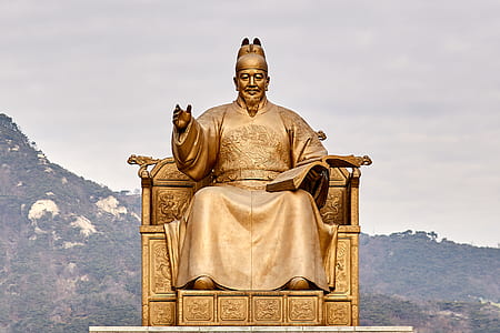 yellow man sitting on chair statue thumbnail